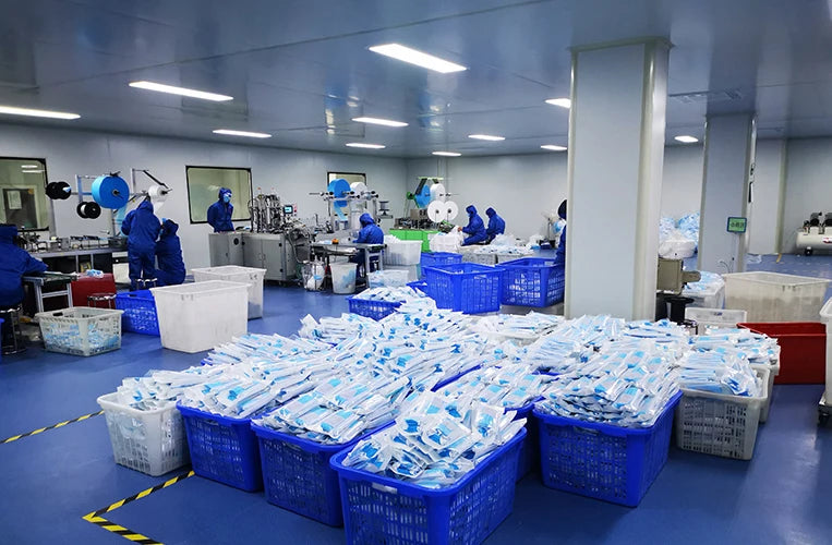 Blue non-woven 3-layer anti-dust disposable masks in white packaging, processed in a clean manufacturing facility.
