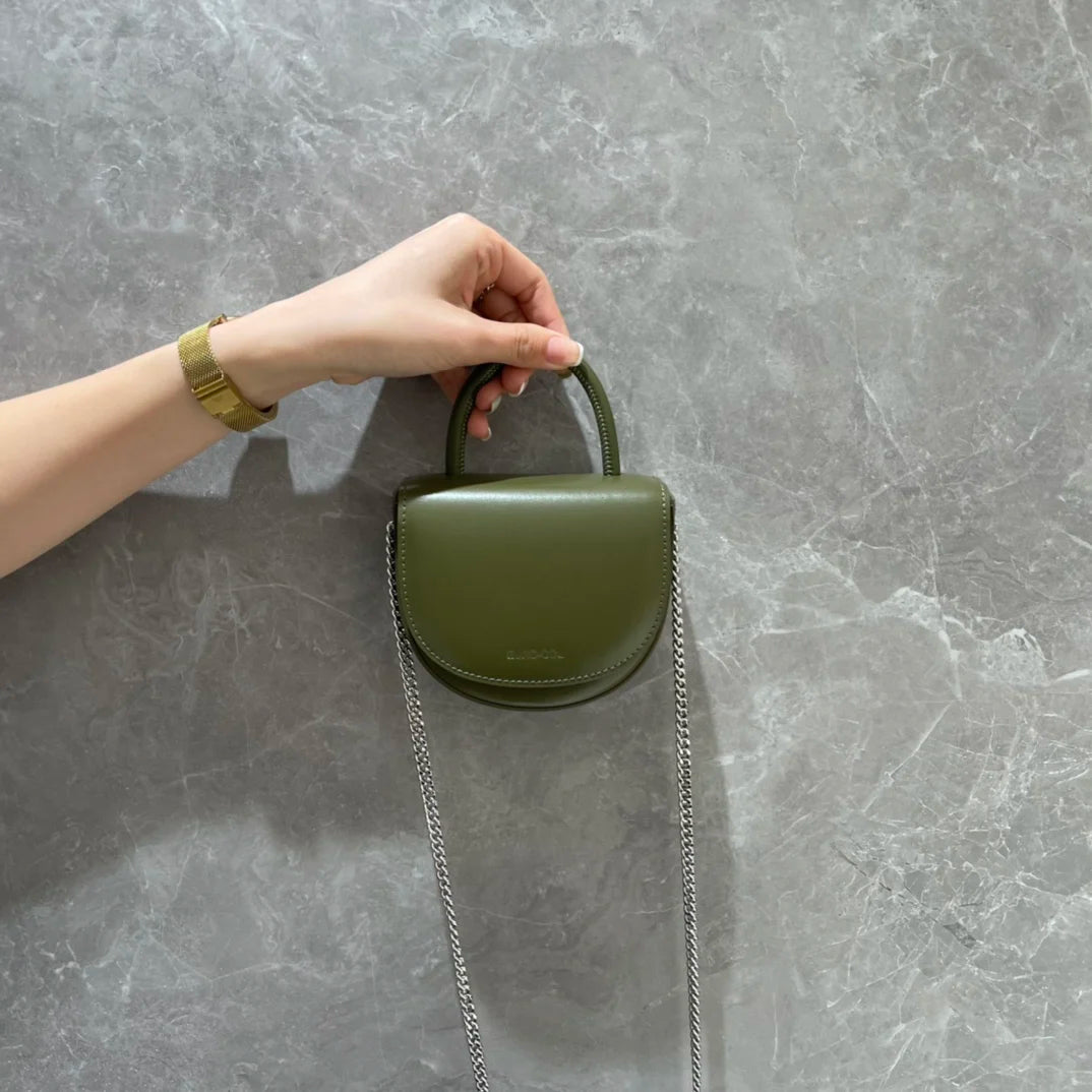 Olive green cowhide leather designer evening clutch with a top handle and silver chain strap for parties or weddings.