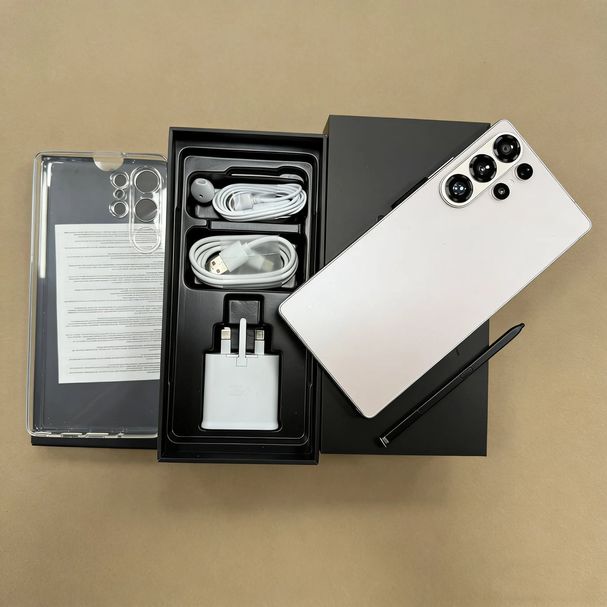 White smartphone with quad rear cameras and open box accessories, cables and charger