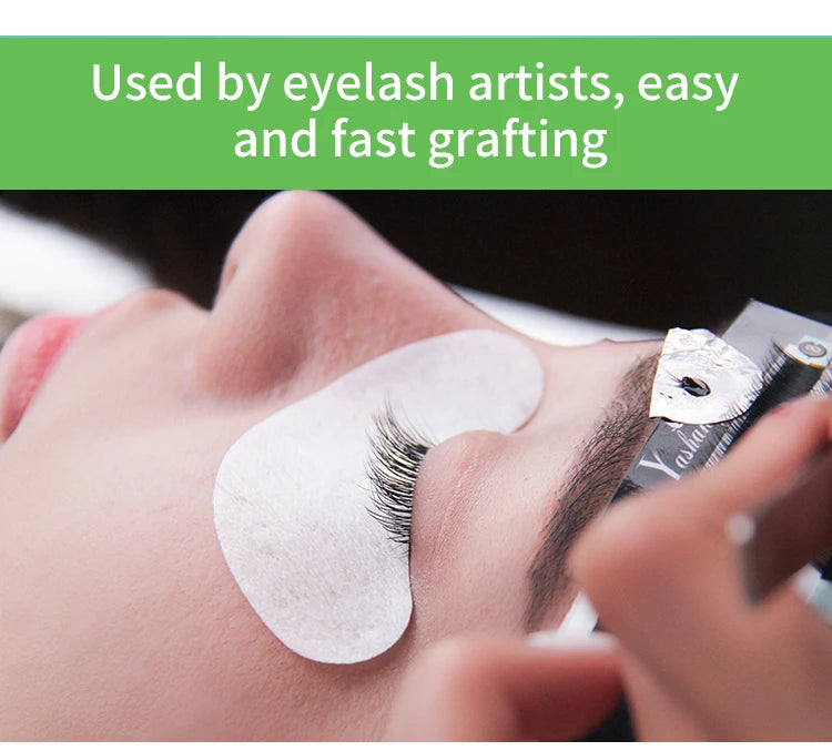 Eyelash artist applying black 3D W-shaped lash extension clusters to a client's eye with an under-eye pad.