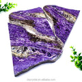 Polished purple charoite slice stone with irregular layered facets and light stone bands