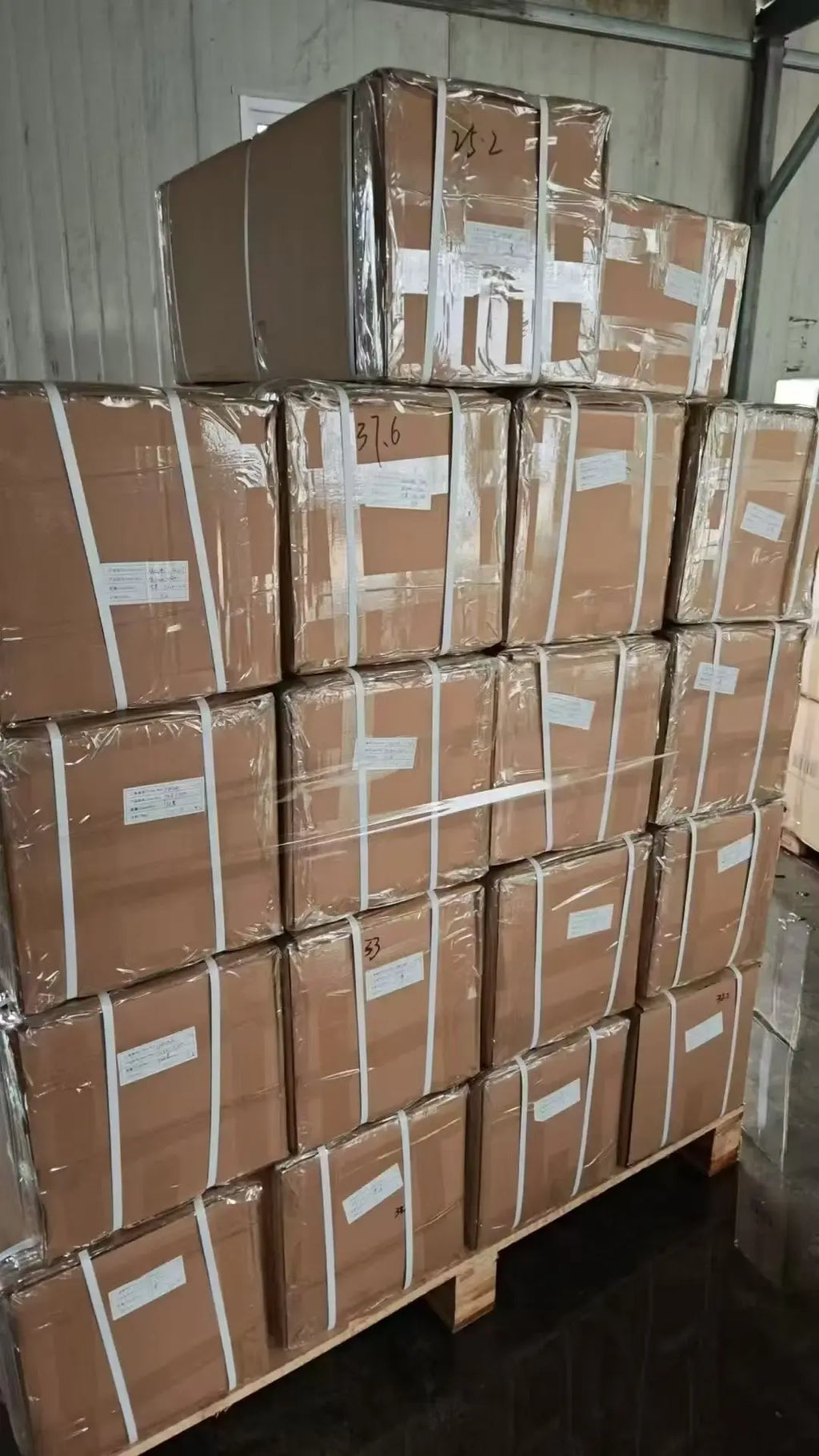 Pallet stacked with brown boxed tape shipments wrapped for storage