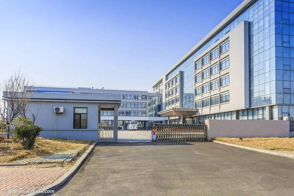 Industrial facility building exterior with paved driveway and fenced courtyard