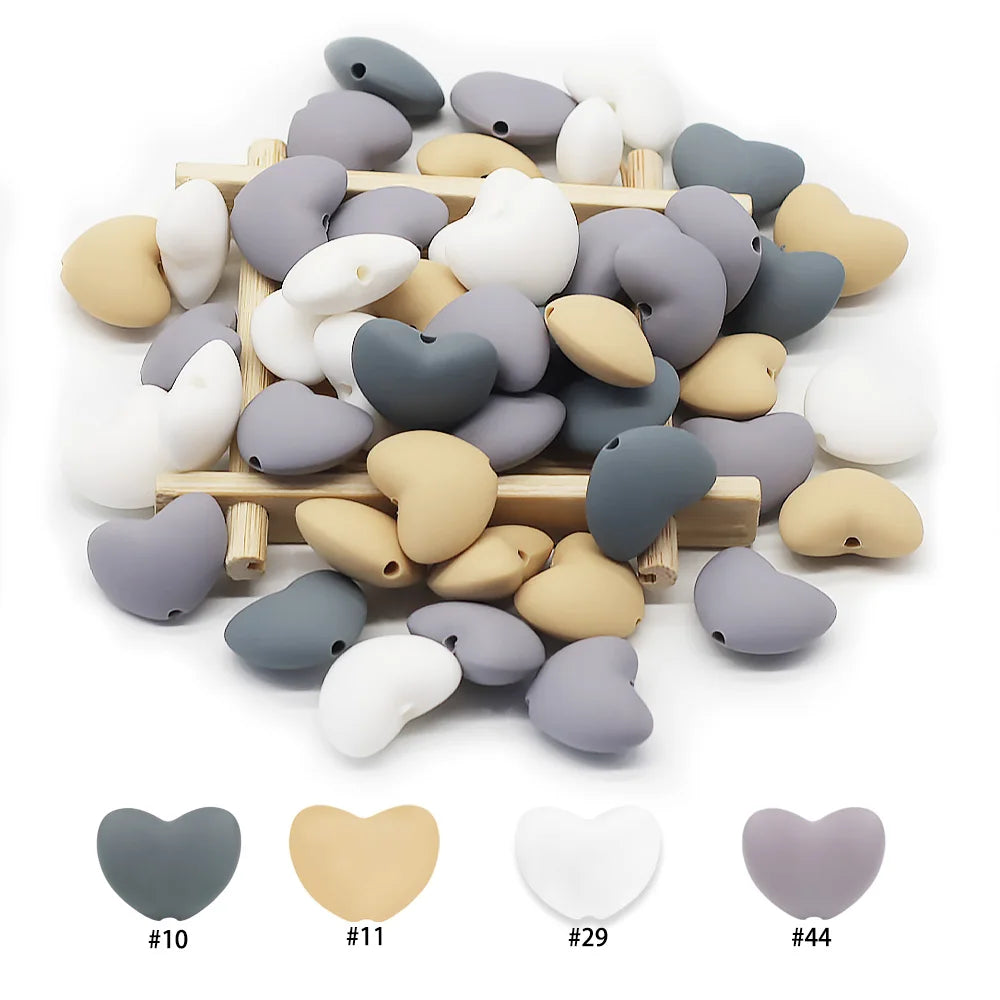 Multi-color silicone heart teething toy beads for DIY baby teething jewelry in grey, beige, and white.