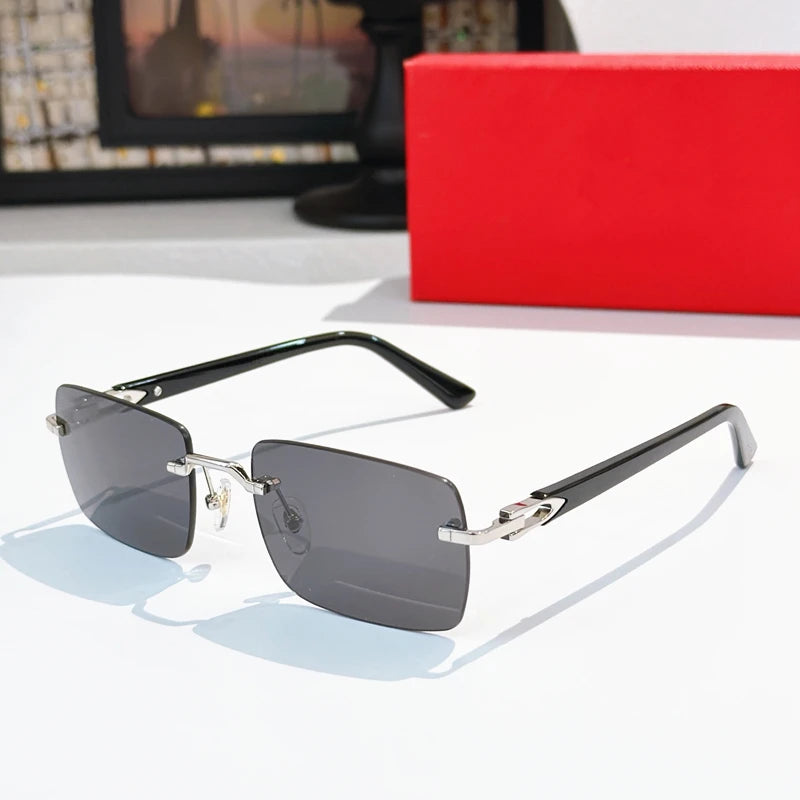 Rimless rectangular sunglasses with silver metal frame, black acetate temples, and grey tinted lenses. Luxury eyewear.