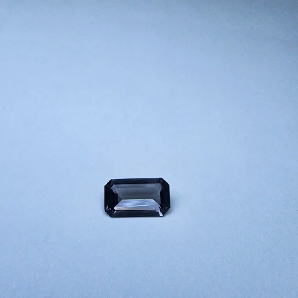 Gray emerald-cut spinel gemstone, rectangular faceted stone