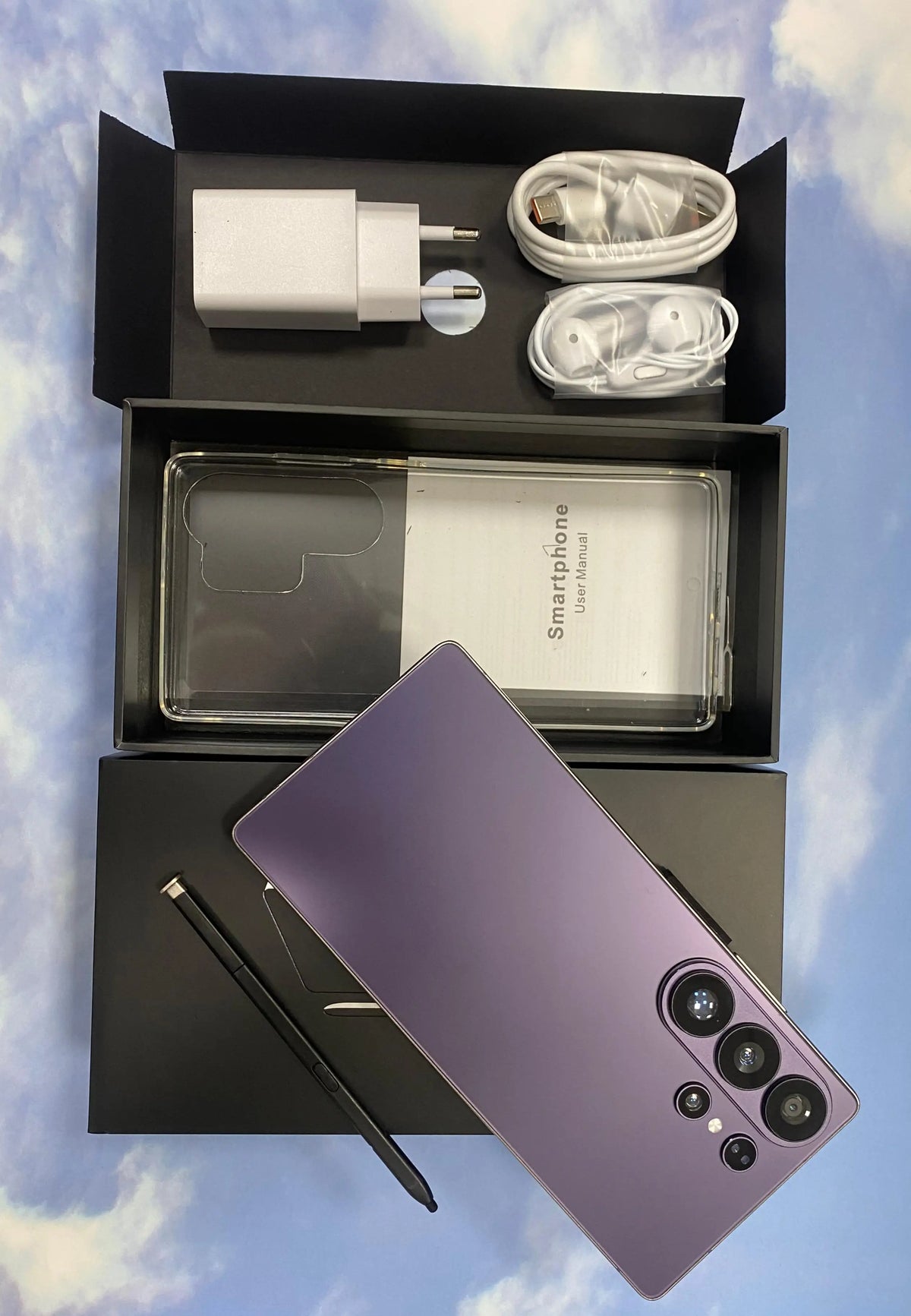 Smartphone unboxing set with purple phone, clear case, charger, and cable