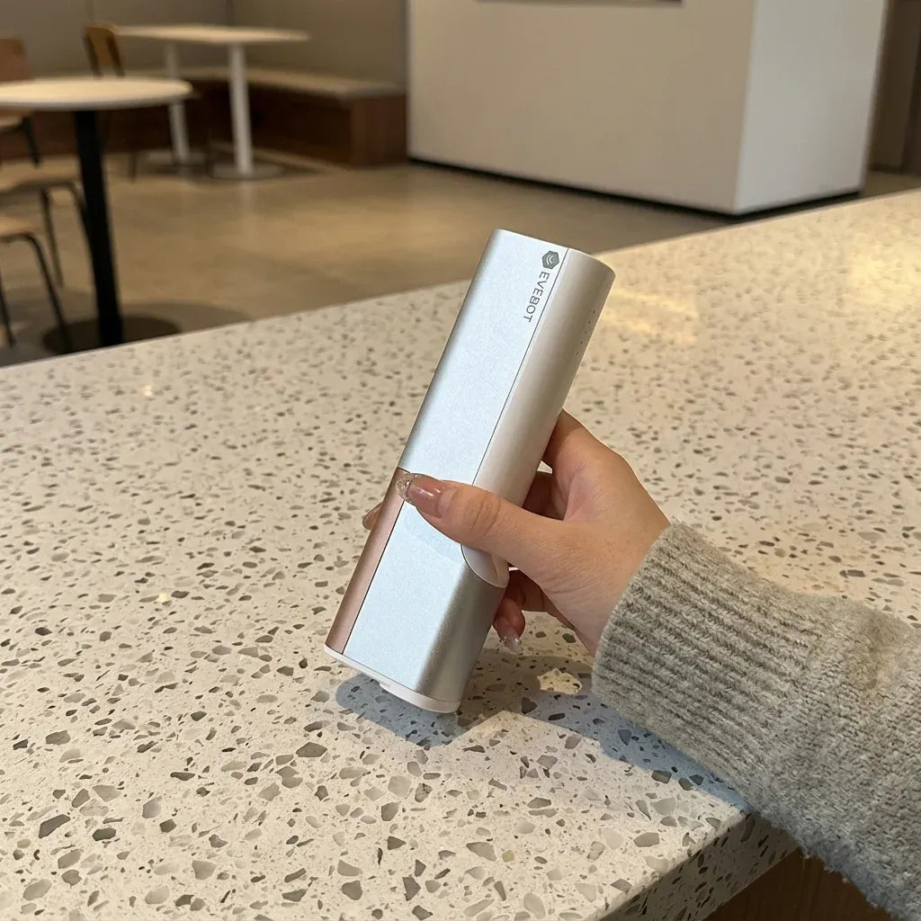 White handheld coffee printer pen held above a countertop