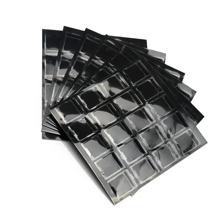 Stack of black and silver-backed urethane foam tape pieces with square openings