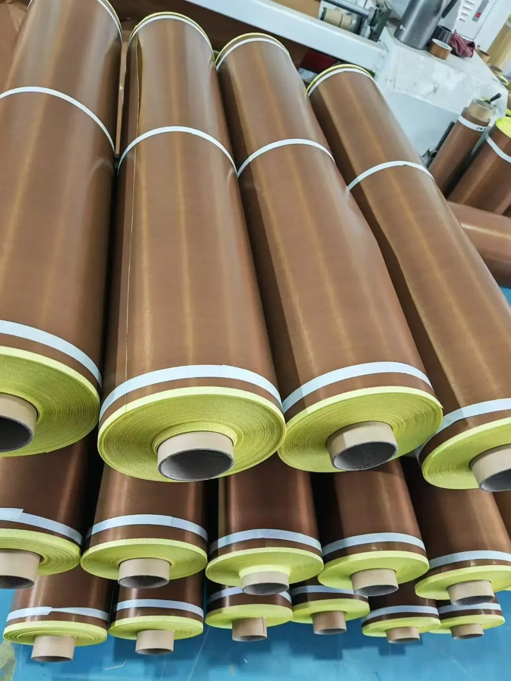 Bulk rolls of brown tape with green edge labels stacked tightly