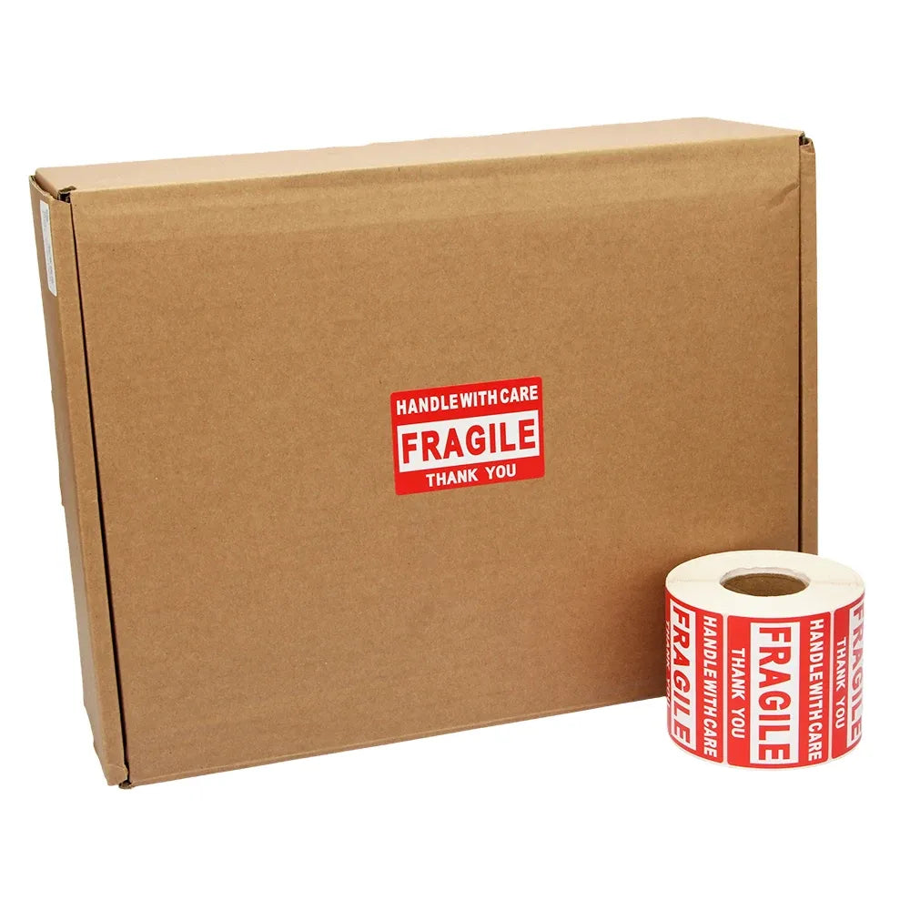 Fragile shipping label roll beside a brown cardboard shipping box