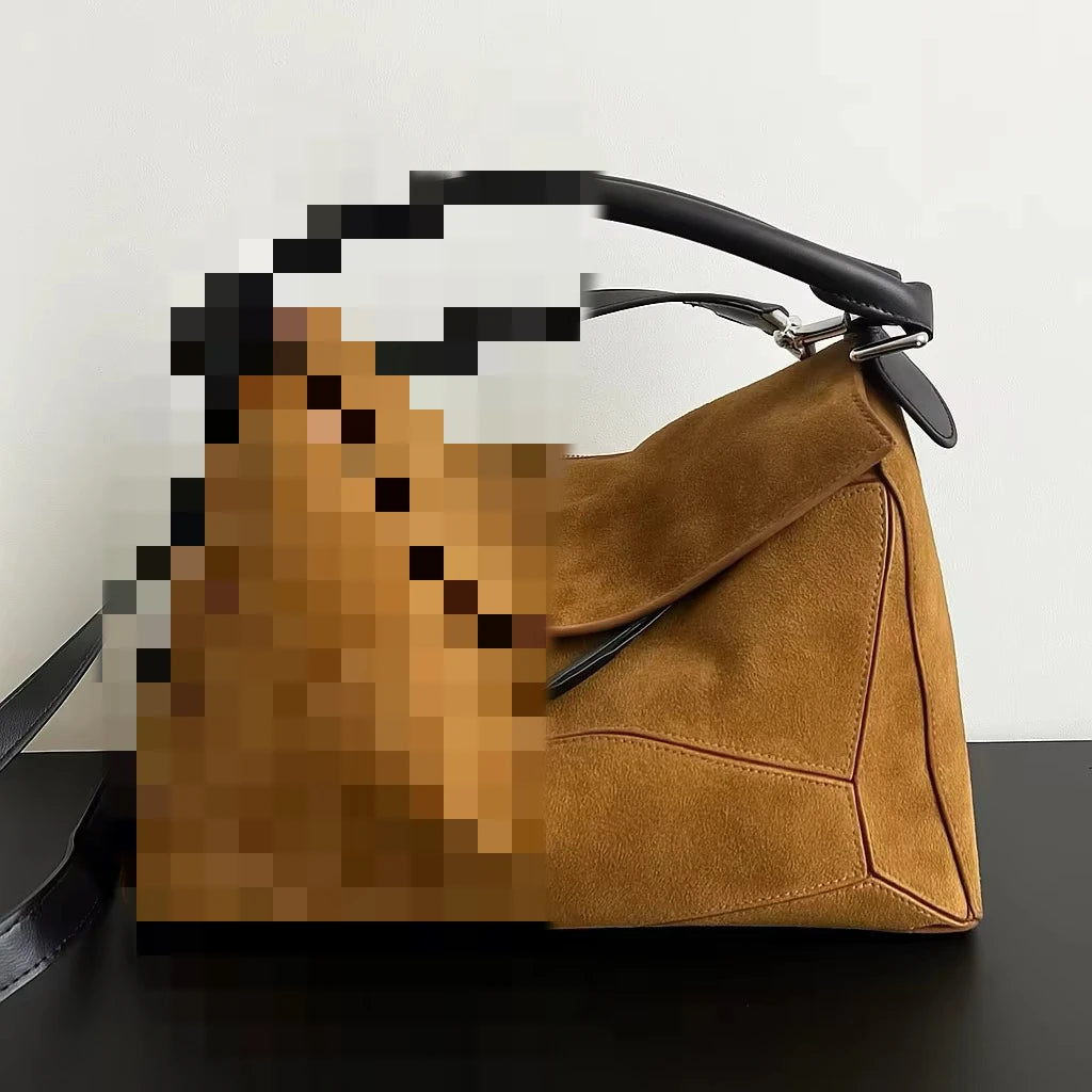 Tan suede designer handbag with structural geometric panels and black leather handle. Stylish luxury crossbody tote.