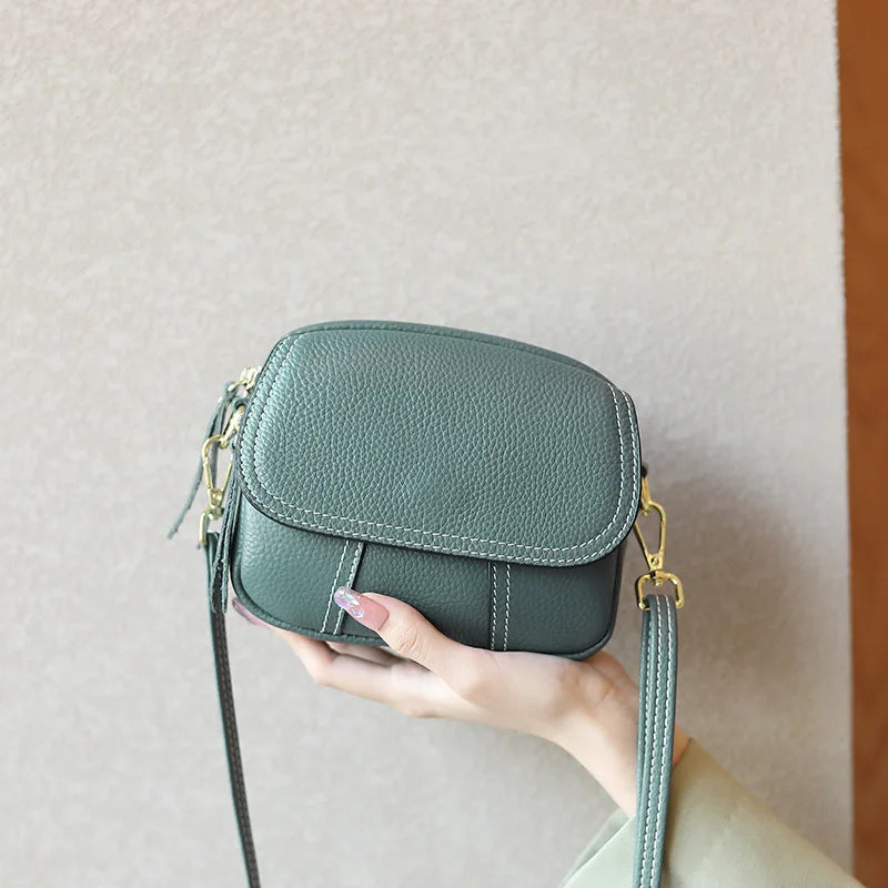 Green genuine leather mini crossbody bag with gold hardware, contrast stitching, and a classic flap design.