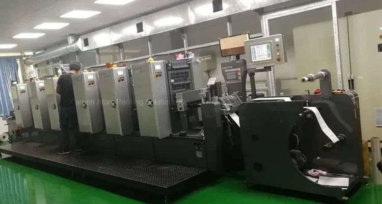 Industrial label printing machine setup with rollers and control panel for production
