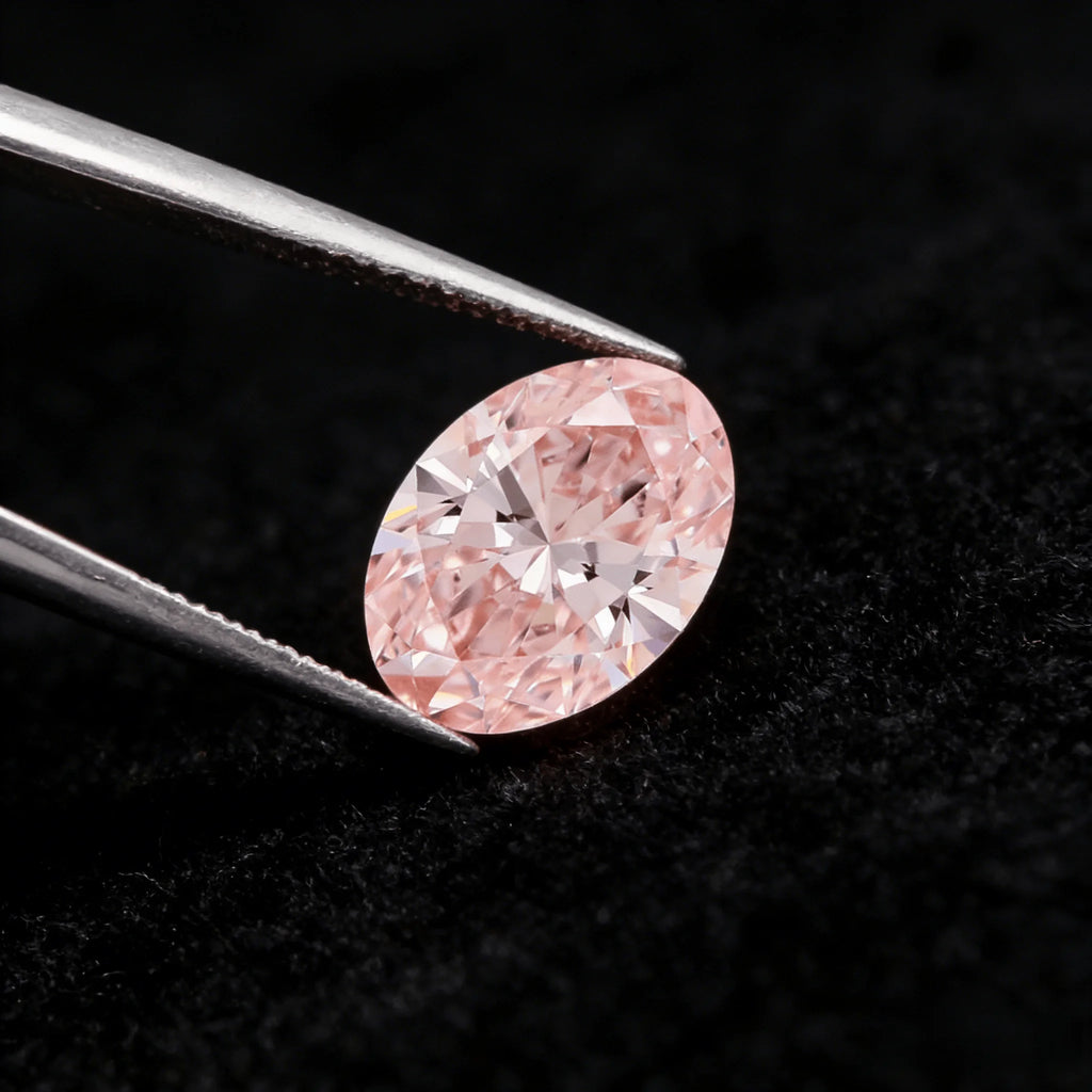 Oval fancy pink lab-grown diamond angled in tweezers, facet reflections