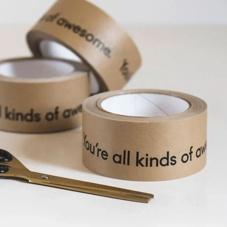 Brown kraft paper packing tape rolls stacked on surface for sealing packages