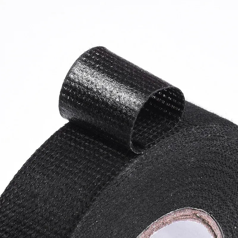 Close-up of black woven insulation tape texture with roll edge and inner core