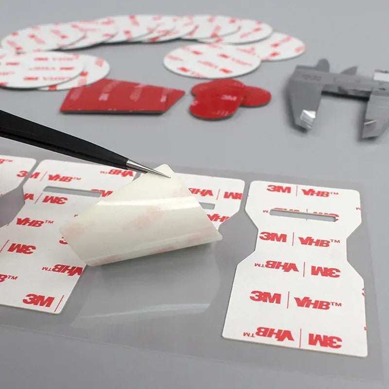 White acrylic foam tape pads with red 3M VHB printed release liners, die-cut pieces