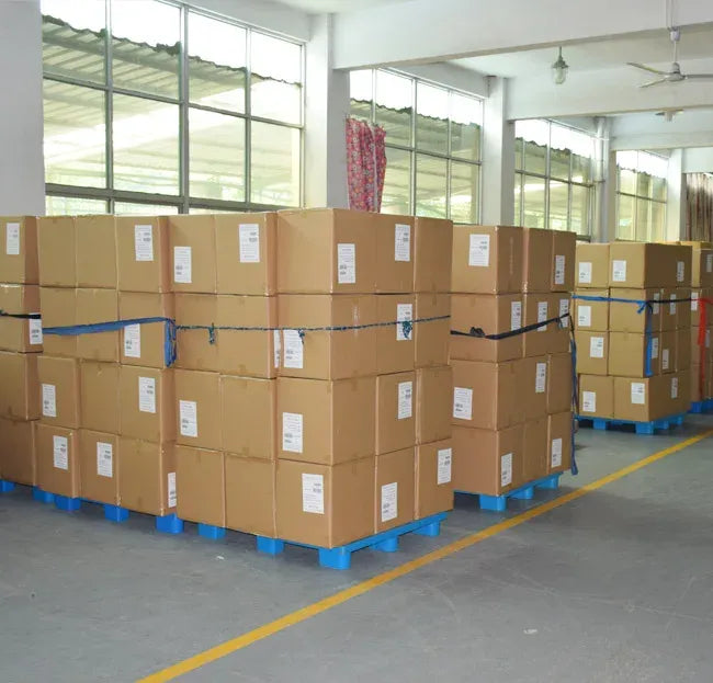 Warehouse with stacked cardboard boxes on pallets along a storage aisle