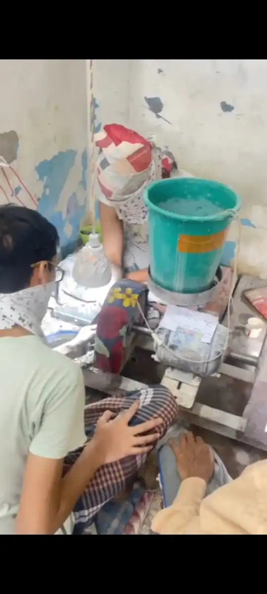 Gemstone workshop scene with people working near containers and colored materials