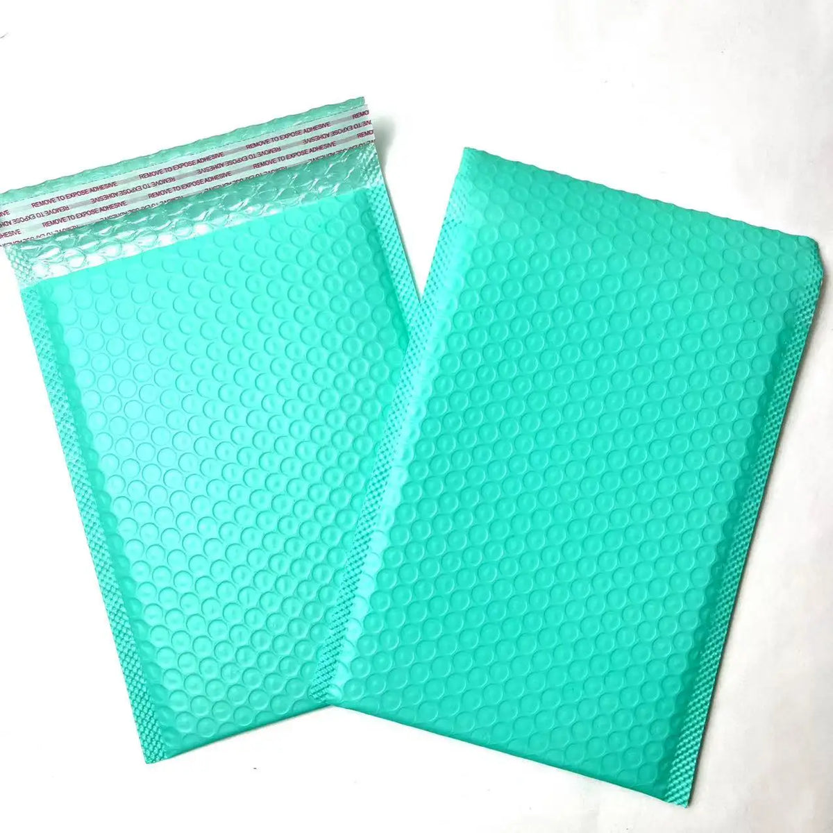 Teal bubble mailer shipping bags with raised bubble-texture poly surface.