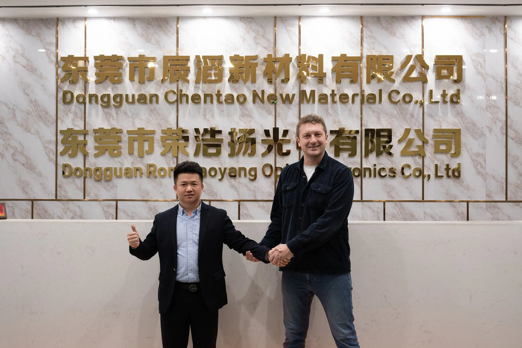Heat-resistant tape company staff shaking hands in front of office signage