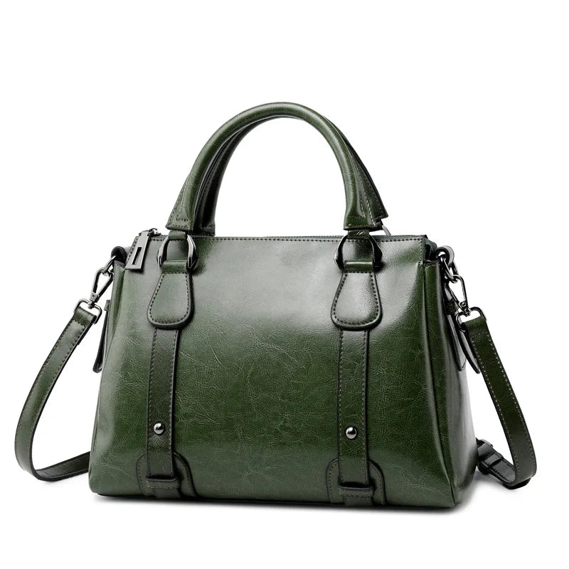 Dark green genuine cow split leather designer handbag with top handles, shoulder strap, and vintage-style buckle detail.
