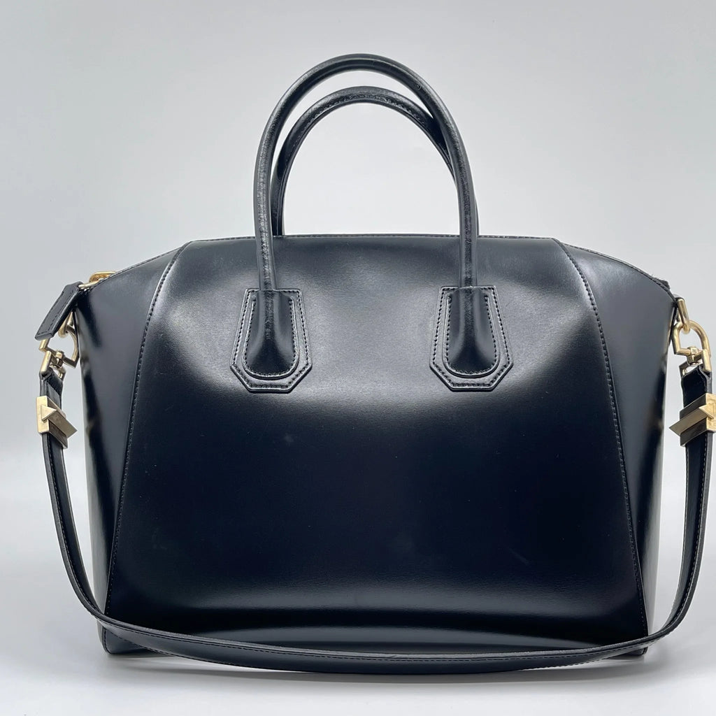 Luxury pre-owned black leather designer handbag, tote and crossbody style with gold hardware.