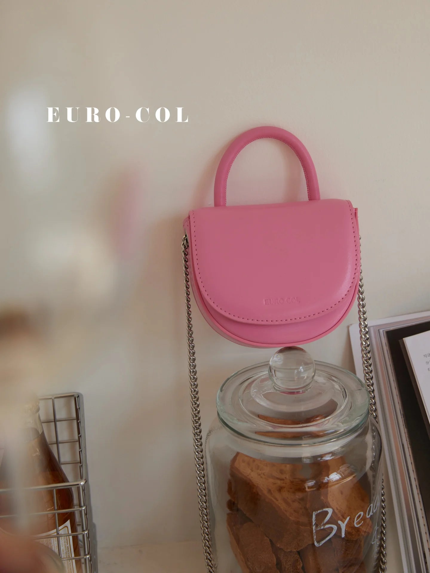 Pink cowhide leather mini top handle bag with silver chain strap, perfect as a designer evening clutch for parties.