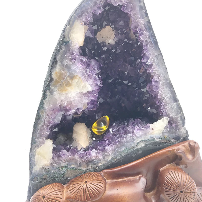 Close-up of purple amethyst crystals with glowing yellow ring in the hollow and brown base