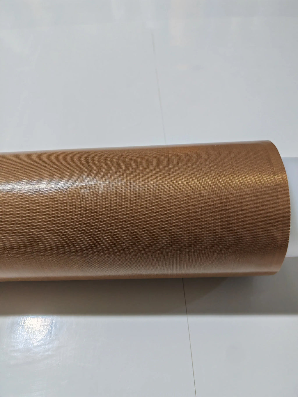 Brown PTFE tape roll close-up of the wound outer layer