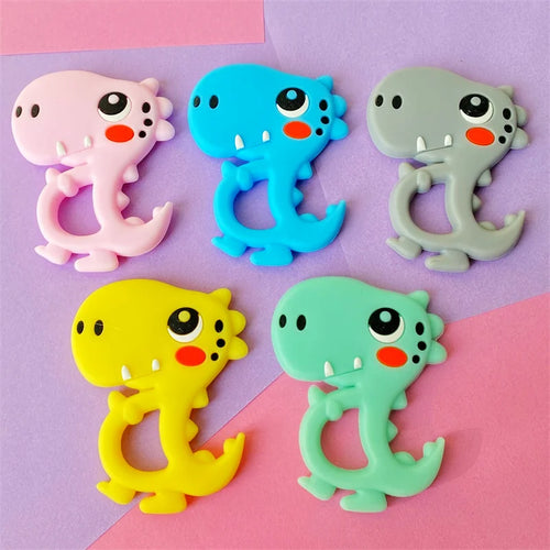 Set of colorful silicone dinosaur baby teething toys in pink, blue, grey, yellow, and mint green.