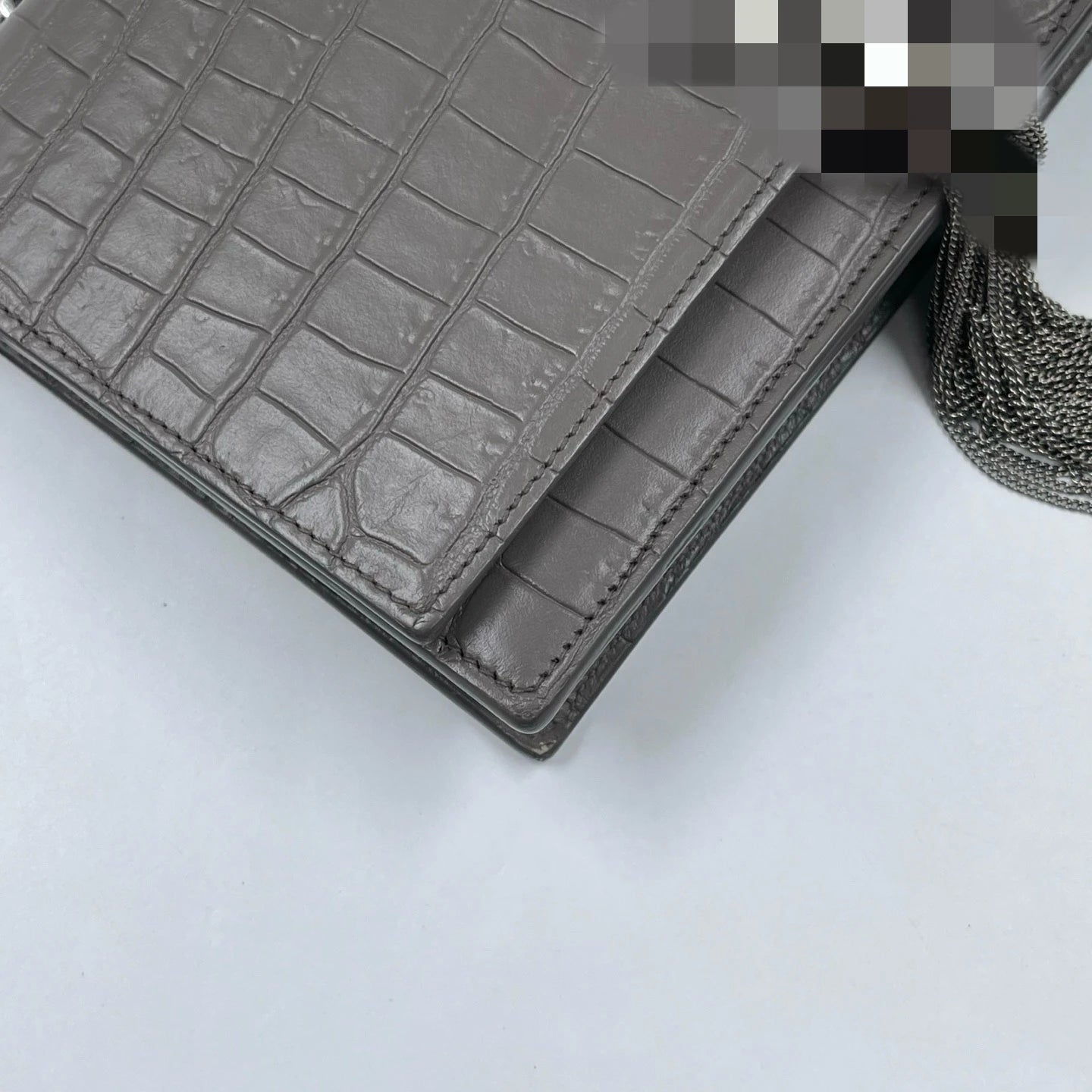 Luxury designer handbag in elephant grey crocodile-embossed leather with a silver metal tassel. Wholesale available.