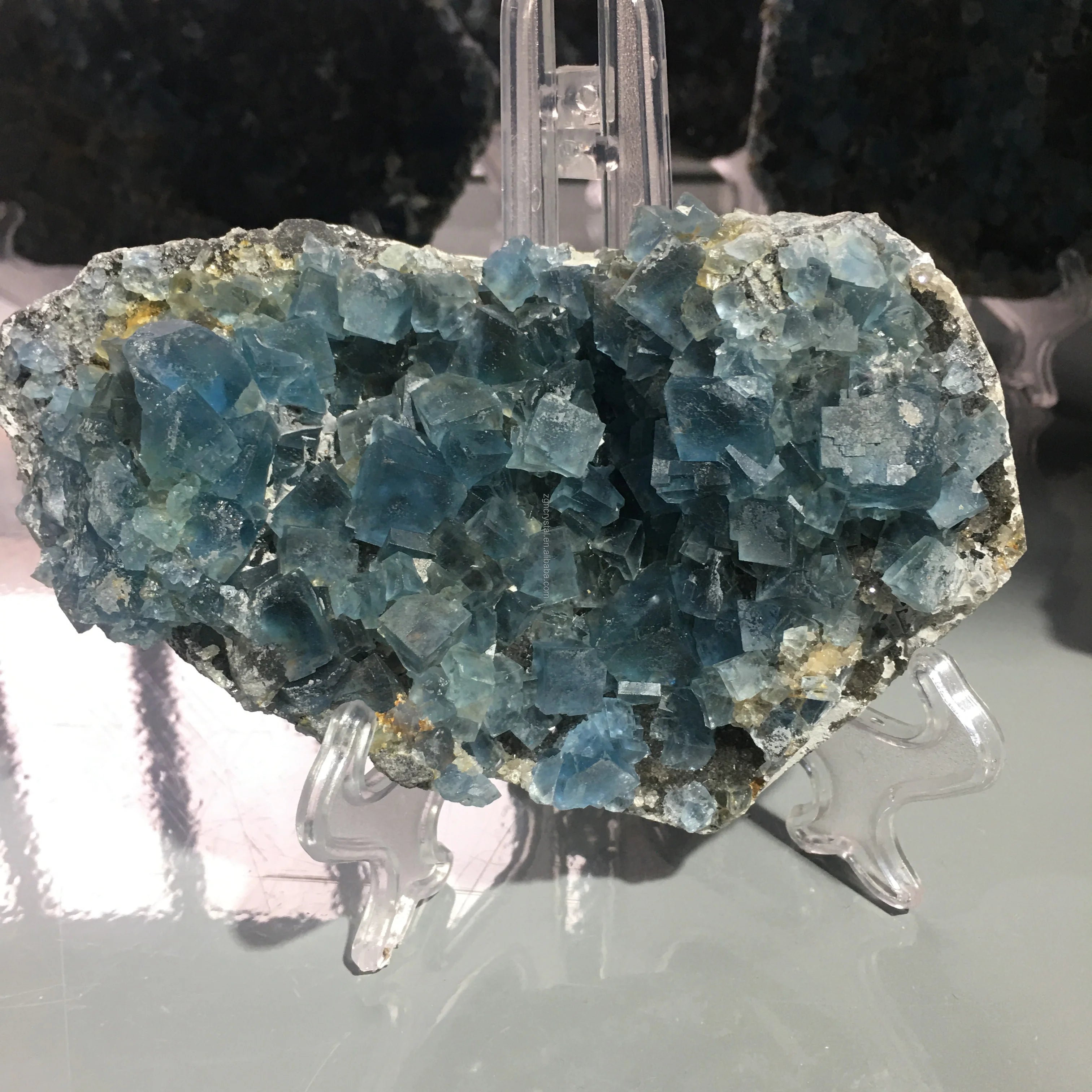 Teal-blue fluorite crystal specimen with cubed crystals and gray mineral base