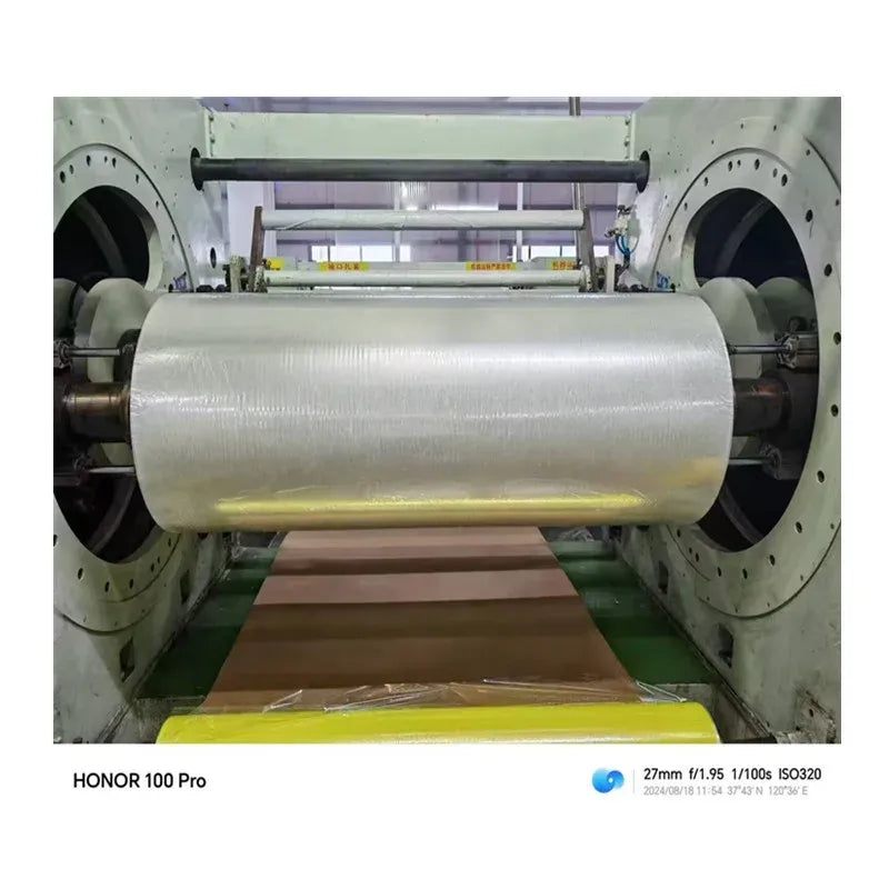 Clear BOPP tape jumbo roll feeding through industrial tape machine