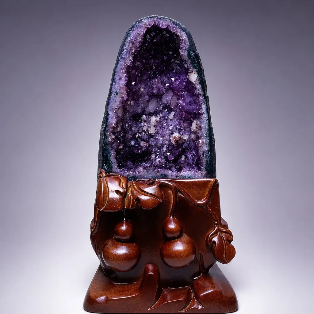 Amethyst geode cluster with dark purple crystals on carved wooden base