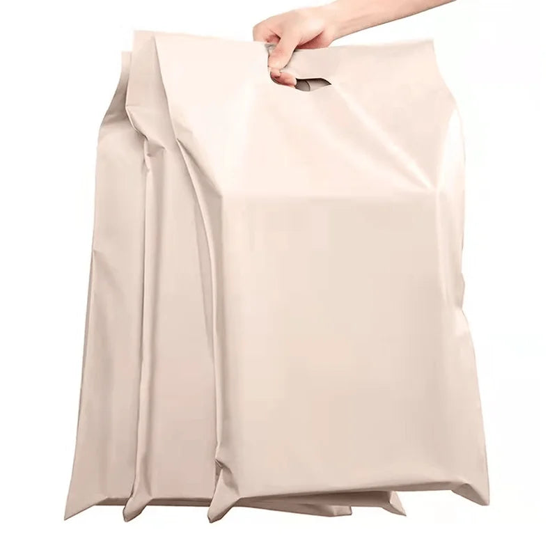 Beige poly mailer with top die-cut handle opening for clothing shipping