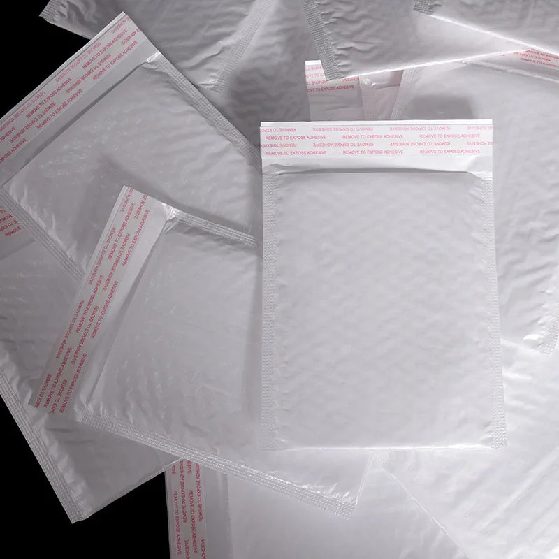 Overlapping white plastic bubble mailer envelopes with printed red-and-blue strip