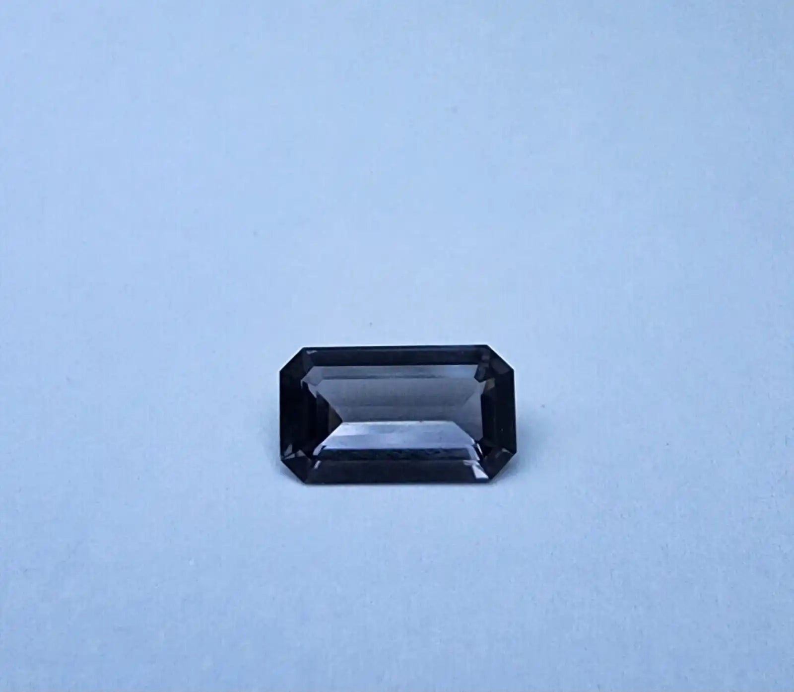 Dark gray emerald-cut spinel gemstone, rectangular step-cut with corners