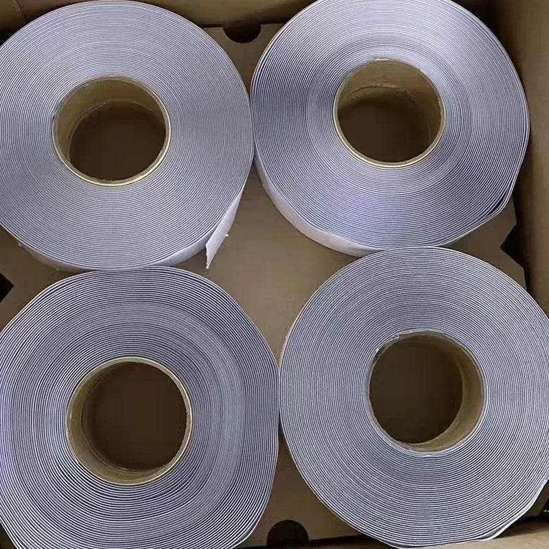 Silver-gray waterproof foil tape rolls, stacked with inner core exposed