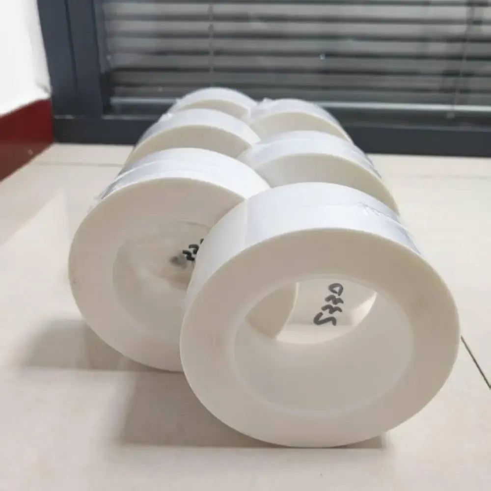 White PE shrink wrap tape rolls laid diagonally, showing wide roll ends