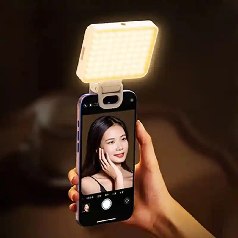 White clip-on LED square light attached to a smartphone for enhanced selfie lighting.