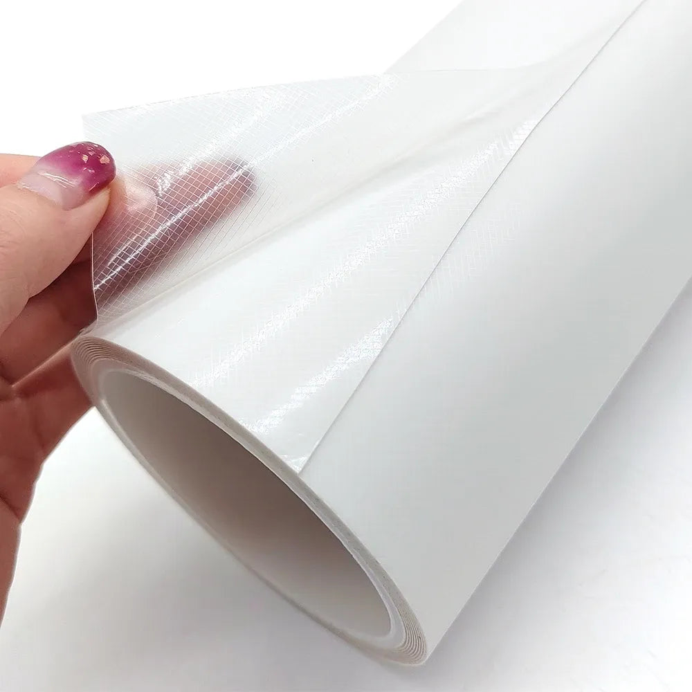Double-sided mounting tape with protective liner, held by hand, white
