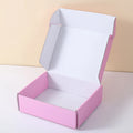 White and pink mailer box with open lid and flat base, shipping packaging