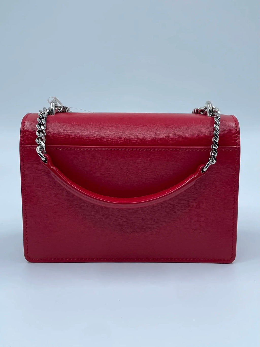 Luxury red genuine leather designer crossbody bag with a silver chain strap and top handle.