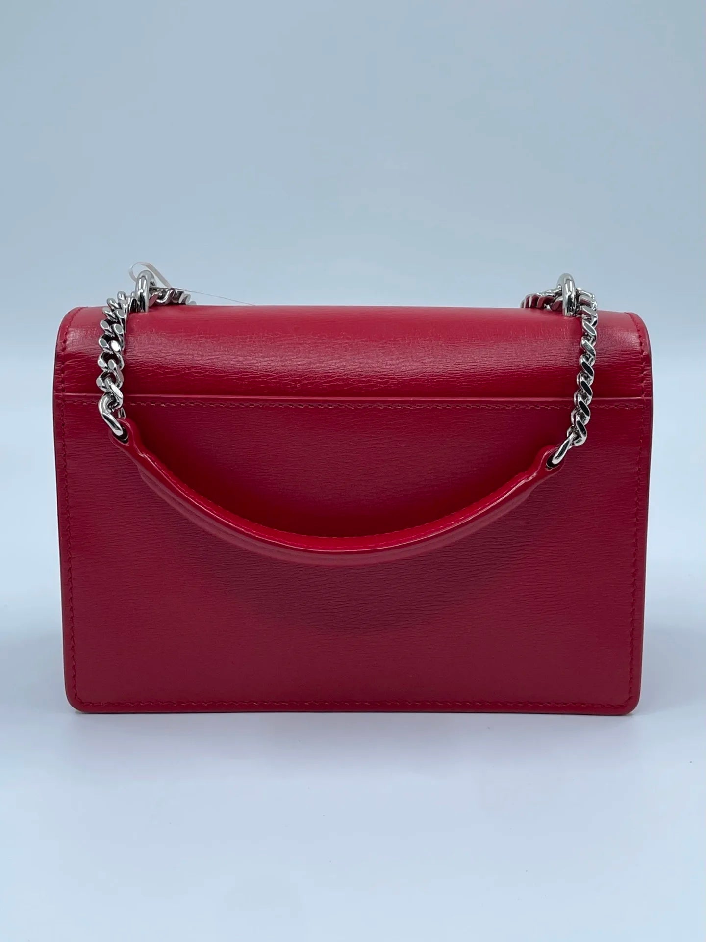Luxury red genuine leather designer crossbody bag with a silver chain strap and top handle.