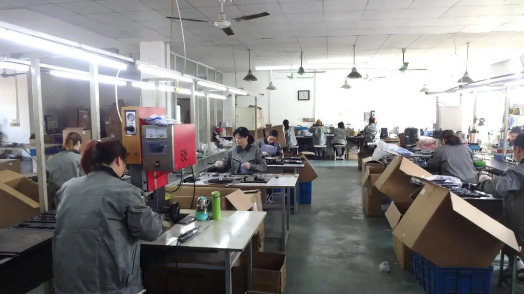 Workshop scene with workers assembling label printer tape cassettes at benches