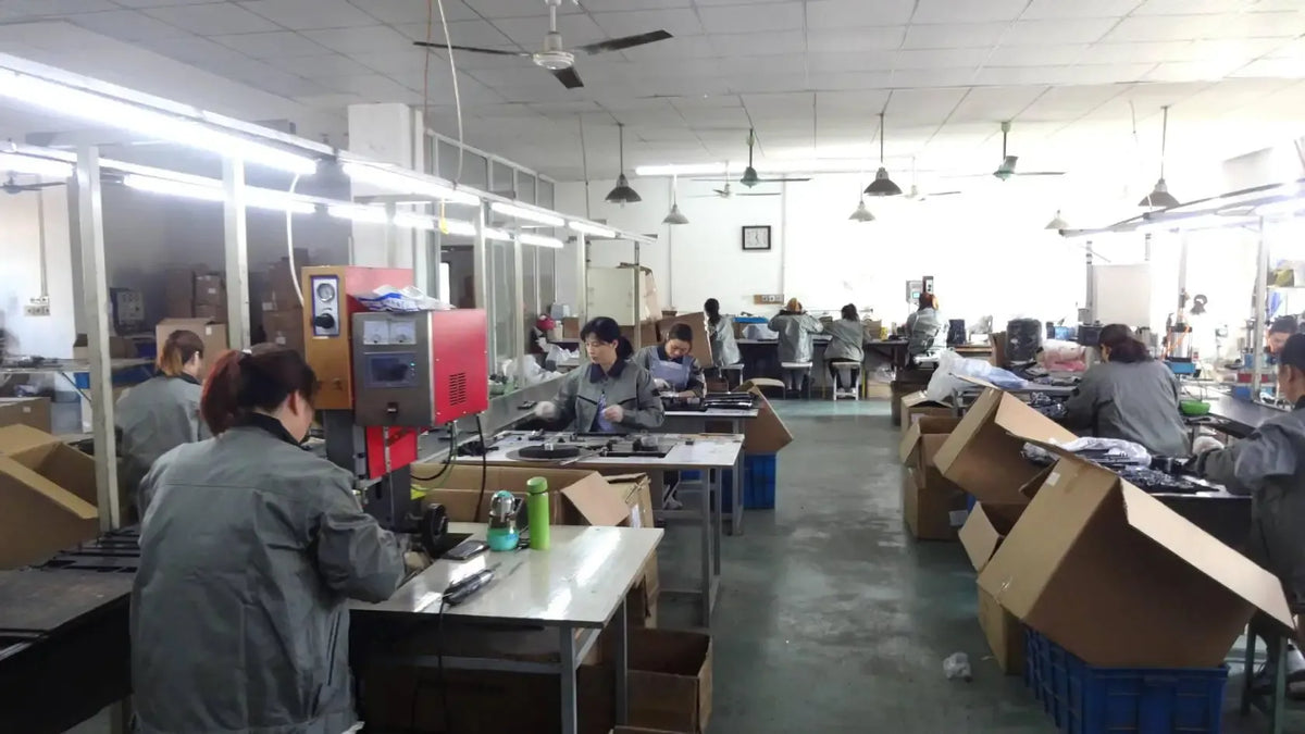 Workshop scene with workers assembling label printer tape cassettes at benches