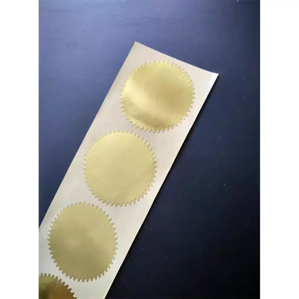 Gold round self-adhesive paper stickers on strip sheet with scalloped borders