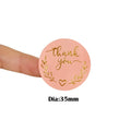 Pink round thank you sticker held up, gold wreath and heart; Dia:35mm